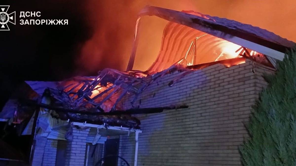 Рятувальник ДСНС гасить полум'я у пошкодженому вікні житлового будинку в передмісті Запоріжжя
