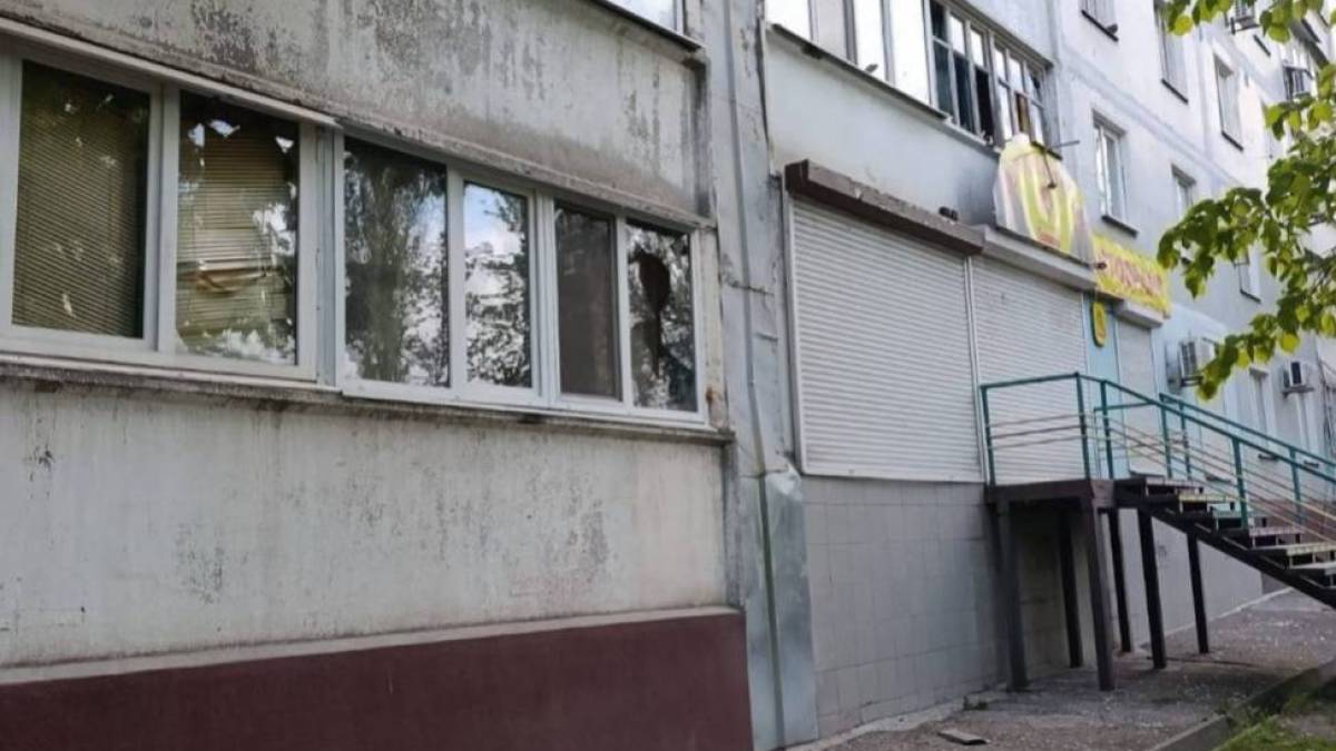 Пошкоджений житловий будинок у Запоріжжі після ворожого удару — вибита скляна облицювання фасаду