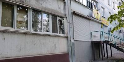 Пошкоджений житловий будинок у Запоріжжі після ворожого удару — вибита скляна облицювання фасаду