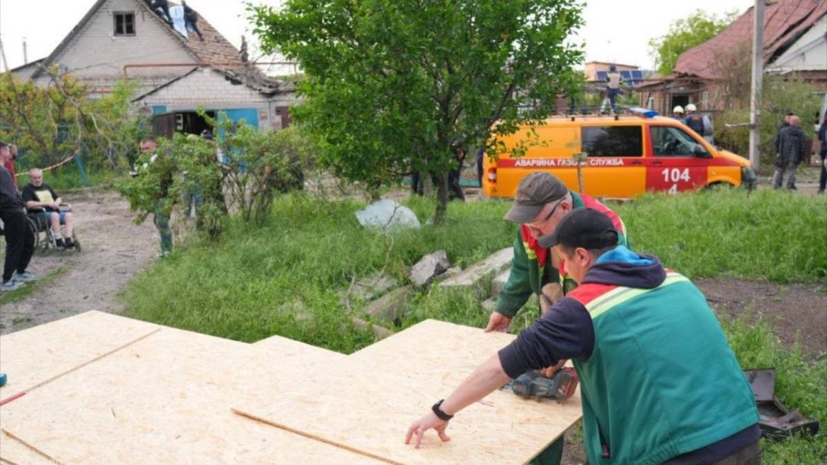 Комунальники та волонтери відновлюють покрівлю пошкодженого будинку у Запоріжжі після ворожої атаки