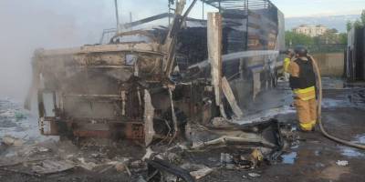 Рятувальник гасить вщент згорілий вантажний автомобіль у Запоріжжі після ворожого обстрілу