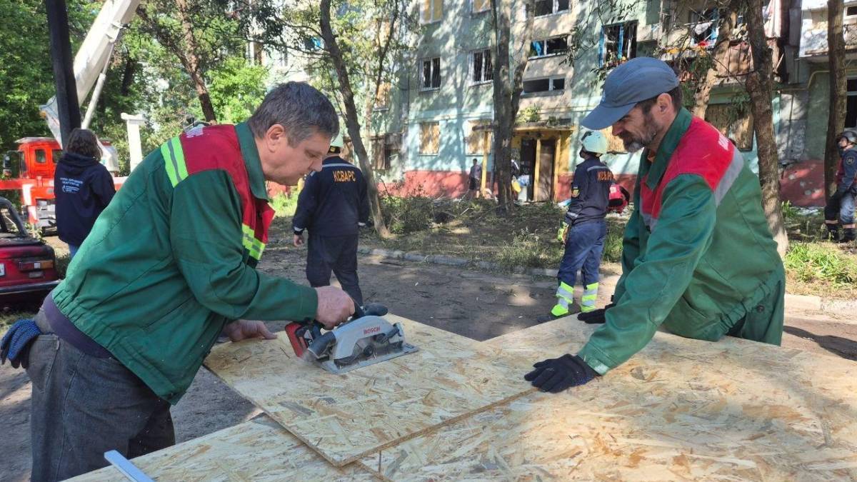 Комунальники закривають вікна у пошкодженому будинку в Запоріжжі