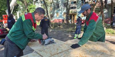 Комунальники закривають вікна у пошкодженому будинку в Запоріжжі